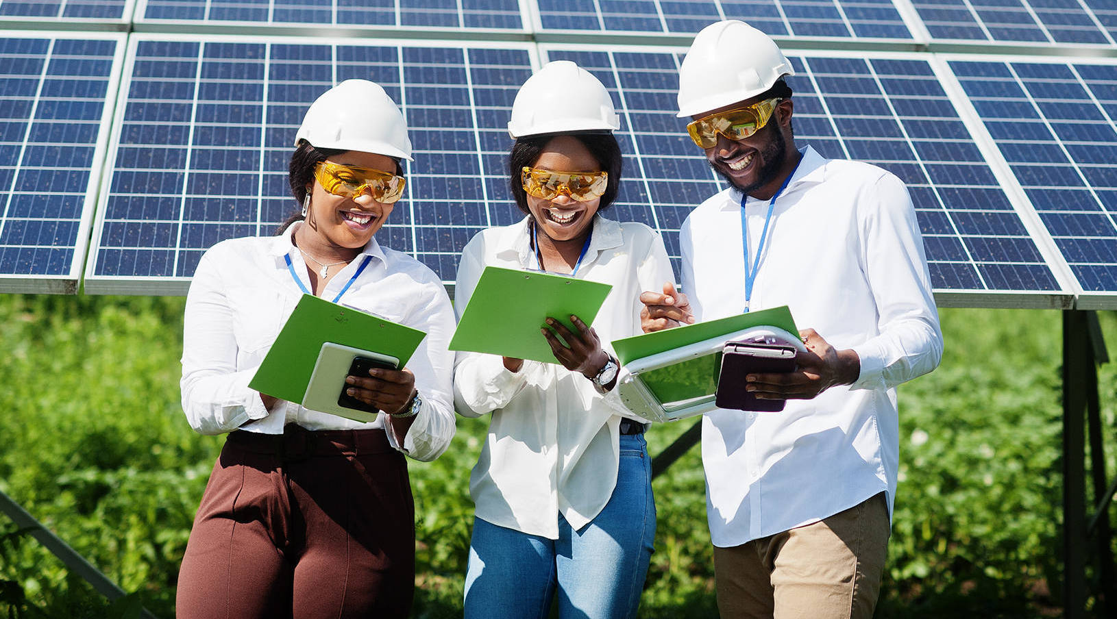 African american technician checks the maintenance of the solar African american technician checks the maintenance of the solar panels. Group of three black engineers meeting at solar station.