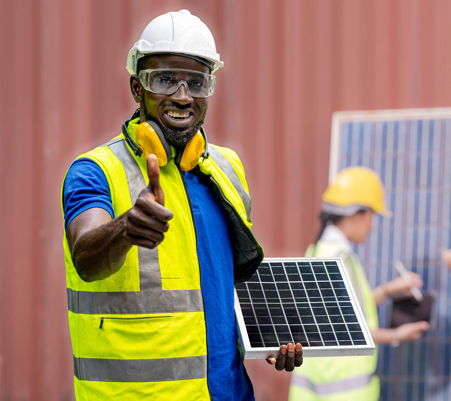 Factory engineer African man standing confidence and holding sol Factory engineer African man standing confidence and holding solar cell panel for renewable energy engineering. Worker staffs checking solar cell panel for renewable energy construction.